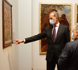 Su Majestad el Rey observa una de las obras en presencia de la ministra de Justicia y del comisario de la exposición
